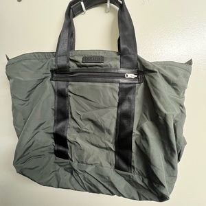 Packable tote bag in mossy green and black from Coach. Bids are welcome!